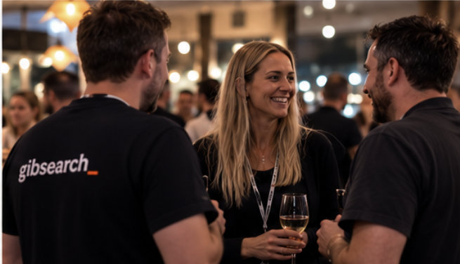 Three people mid-conversation at a GibSearch night, drinks in hand.